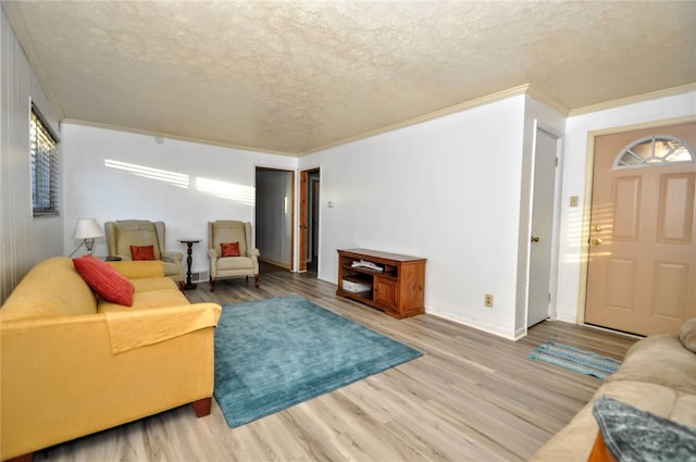 living room featuring ornamental molding, a textured ceiling, and light wood-type flooring