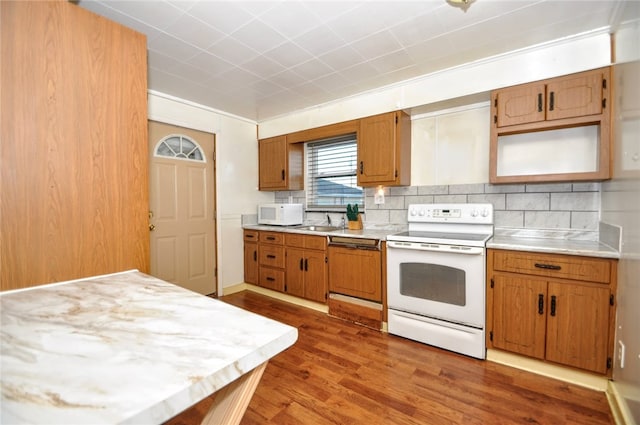 kitchen featuring tasteful backsplash, sink, light hardwood / wood-style floors, and white appliances