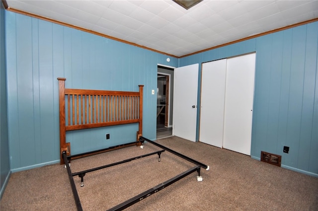 carpeted bedroom with wood walls and ornamental molding