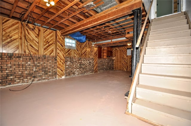 basement with wood walls and brick wall