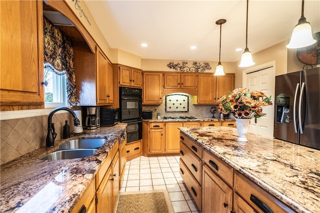 kitchen with tasteful backsplash, sink, black appliances, hanging light fixtures, and light tile patterned flooring