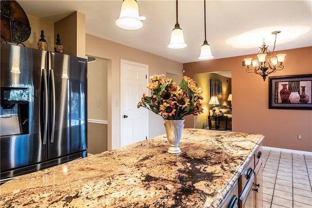 kitchen featuring decorative light fixtures, light stone countertops, light tile patterned flooring, and stainless steel fridge with ice dispenser