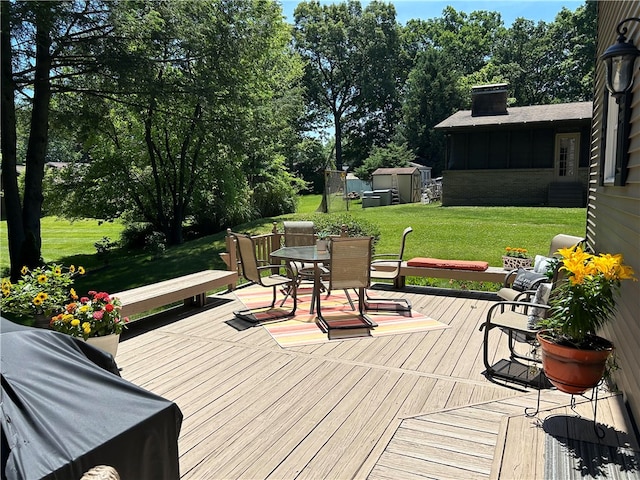 wooden deck featuring a yard and a shed