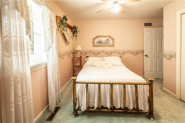 carpeted bedroom featuring ceiling fan and multiple windows