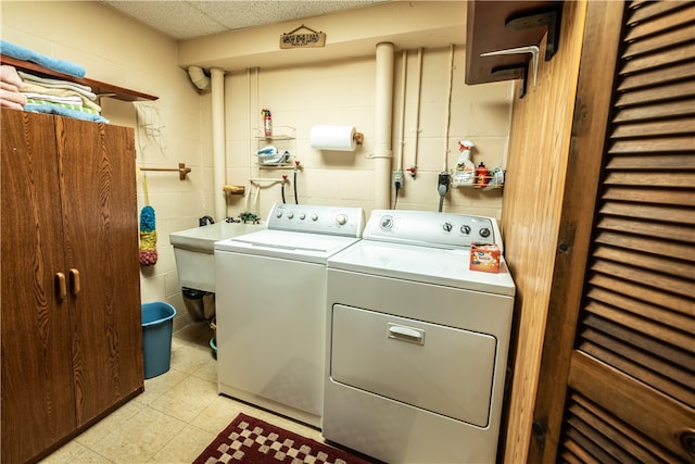 laundry area with separate washer and dryer, sink, and tile walls