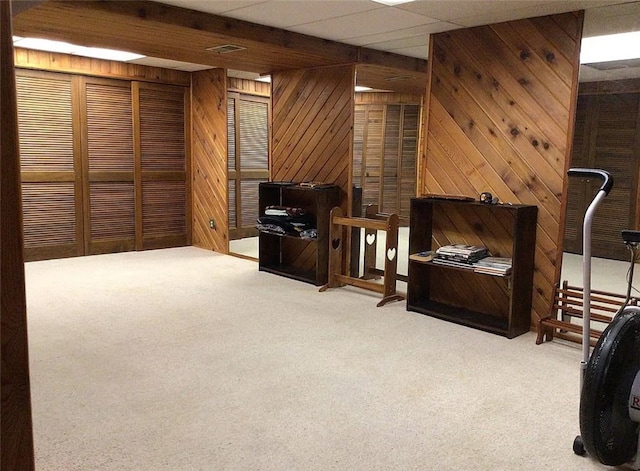 carpeted living room with wood walls