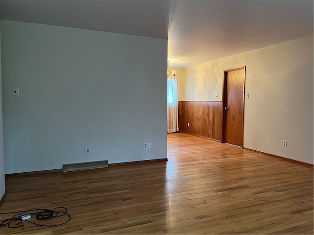 empty room featuring hardwood / wood-style floors and a notable chandelier