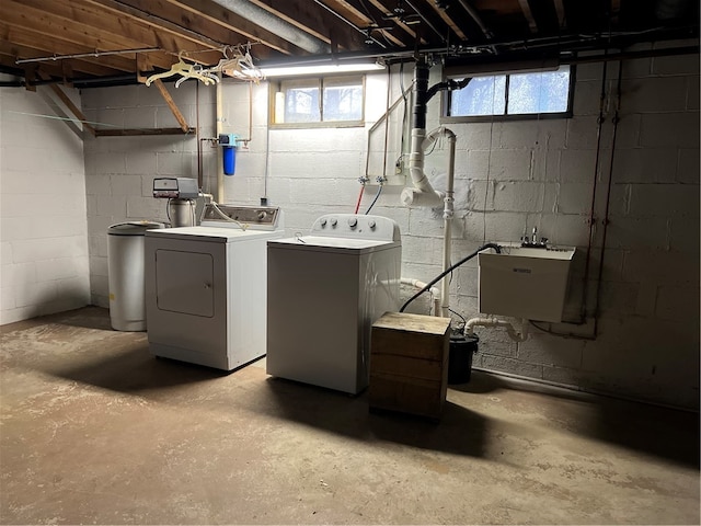 clothes washing area with independent washer and dryer and sink