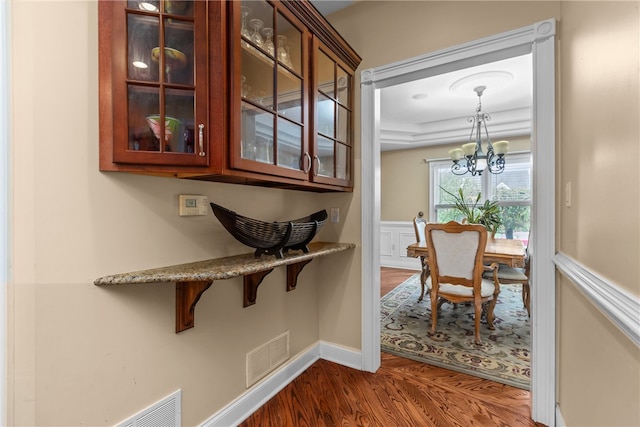 hallway with dark hardwood / wood-style flooring and an inviting chandelier