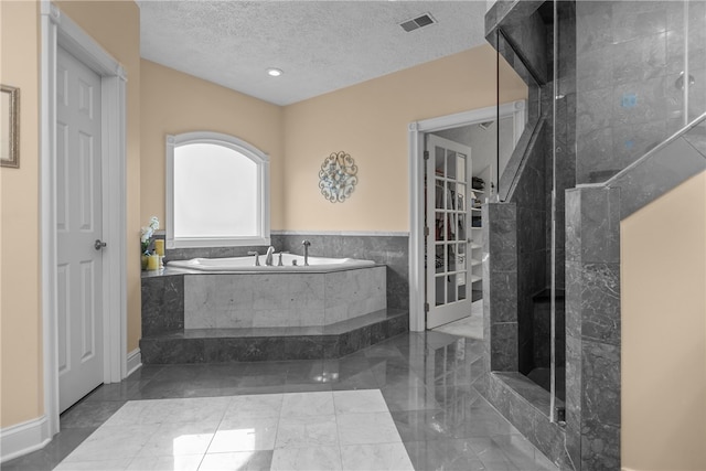 bathroom with plus walk in shower and a textured ceiling