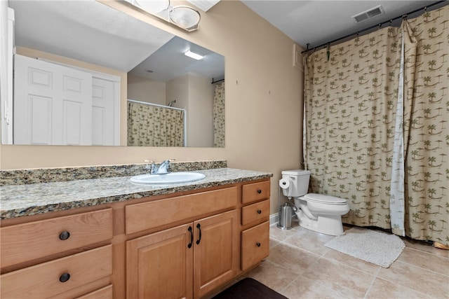 bathroom featuring tile patterned flooring, vanity, toilet, and walk in shower