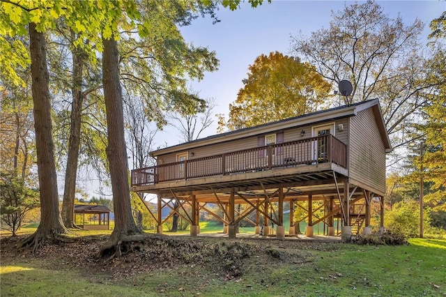 back of property featuring a lawn and a wooden deck
