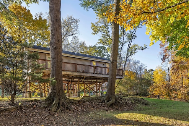 rear view of property featuring a yard and a wooden deck