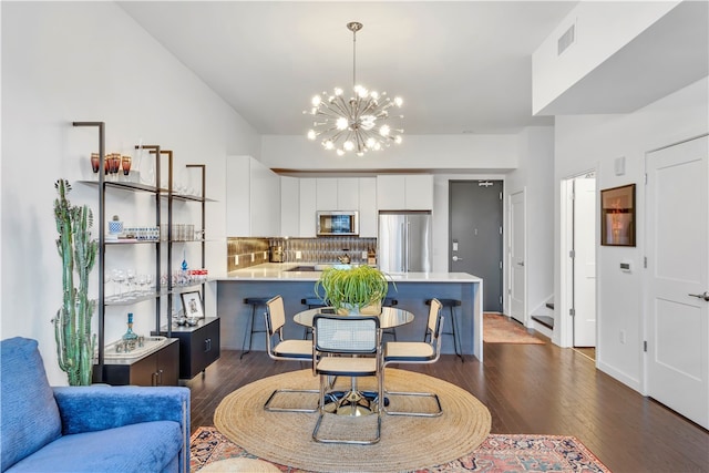 dining room with dark hardwood / wood-style flooring and a chandelier