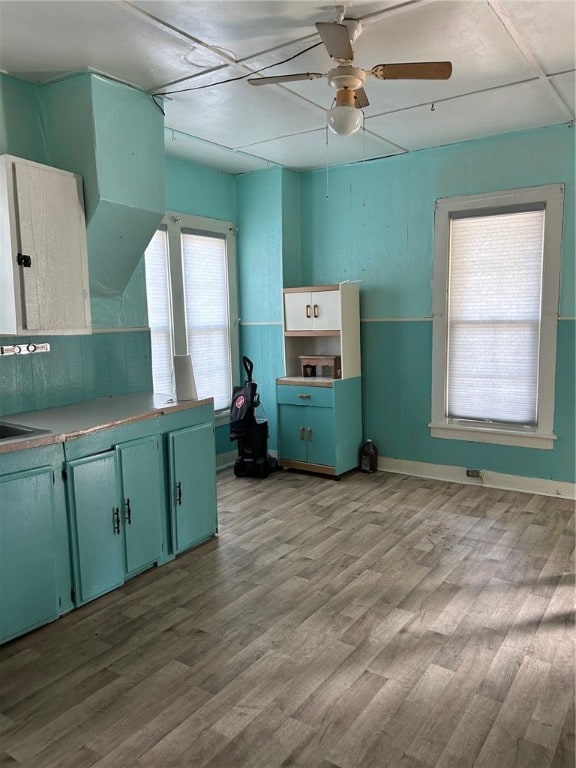 kitchen featuring ceiling fan, green cabinets, and light wood-type flooring