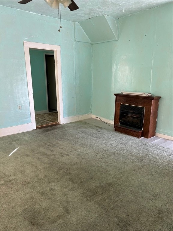 unfurnished living room featuring ceiling fan, carpet floors, and a textured ceiling