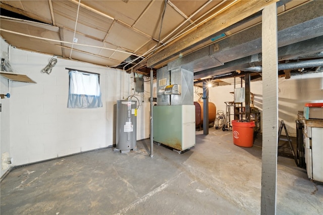 basement featuring heating unit and electric water heater