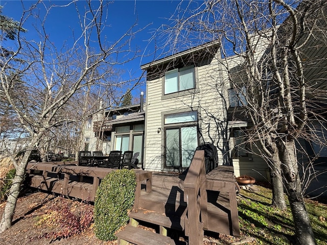 rear view of property featuring a wooden deck