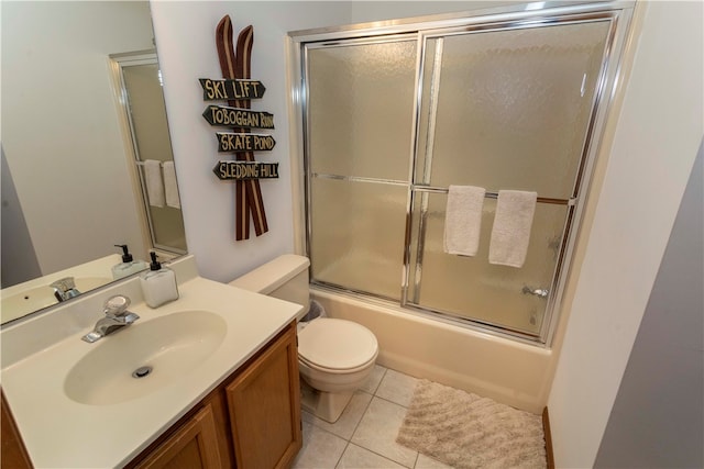 full bathroom featuring toilet, tile patterned flooring, vanity, and combined bath / shower with glass door