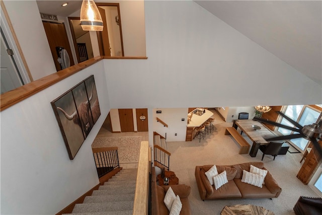 carpeted living room featuring a high ceiling and a skylight