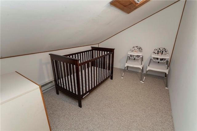 carpeted bedroom featuring vaulted ceiling, a crib, and a baseboard heating unit