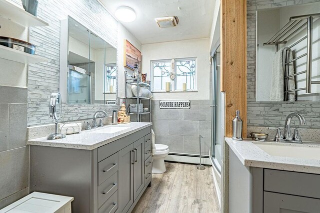 156 Sundust Rd, Nottingham, PA 15330 - full bath featuring a baseboard radiator, toilet, tile walls, wood finished floors, and vanity