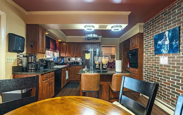 156 Sundust Rd, Nottingham, PA 15330 - kitchen with black appliances, dark countertops, crown molding, brick wall, and dark wood-style floors