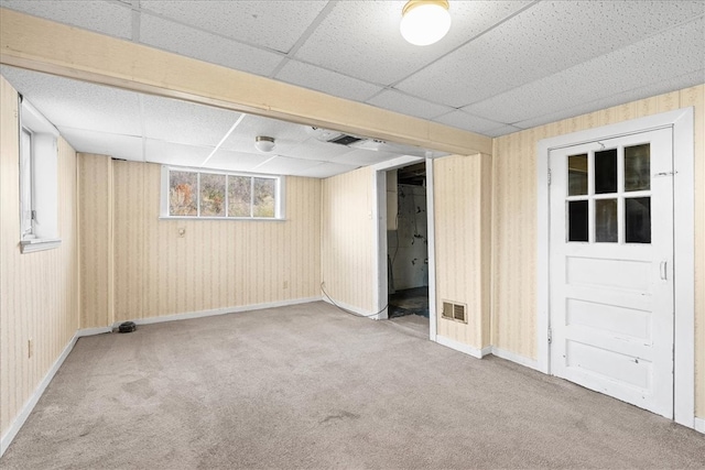 basement with carpet and a paneled ceiling