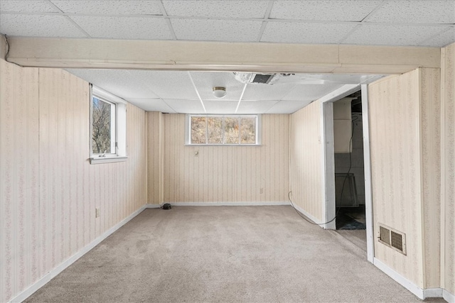 basement featuring carpet floors and a drop ceiling