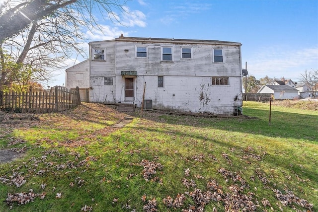 back of house with central AC and a lawn