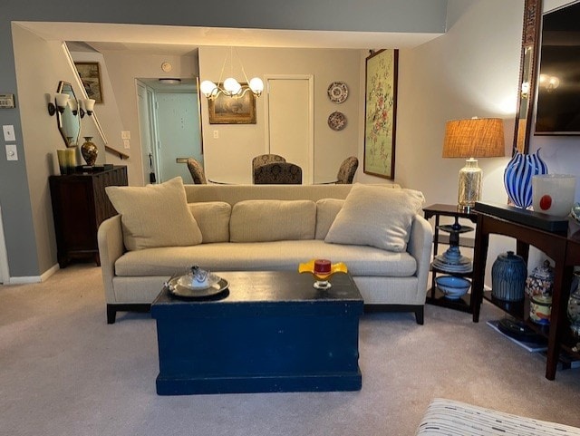 carpeted living room with an inviting chandelier