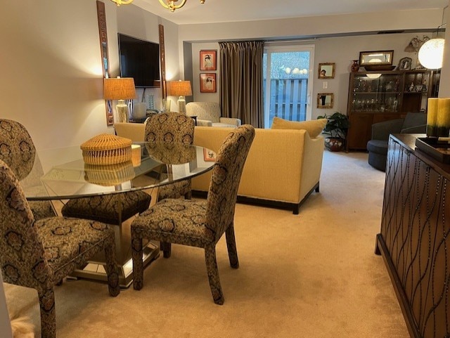 carpeted dining room with a chandelier