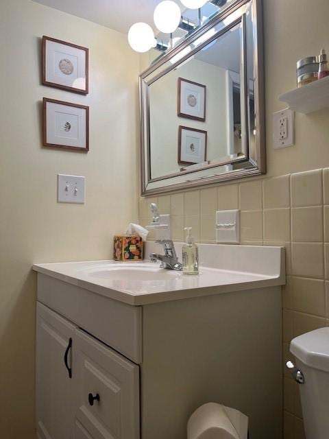 bathroom featuring decorative backsplash, vanity, tile walls, and toilet