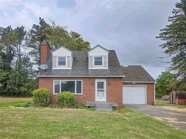 new england style home with a front yard, a garage, and a storage shed