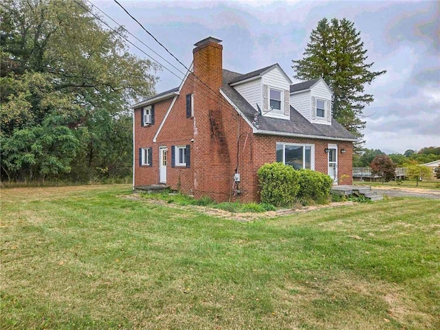 115 Mountain View Dr, E/W Wheatfield Twp, PA 15920 - view of side of home with brick siding, a chimney, and a lawn