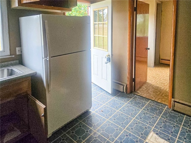 kitchen with white refrigerator and a baseboard heating unit