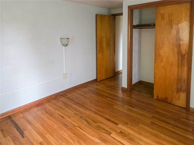 unfurnished bedroom featuring a closet and wood-type flooring