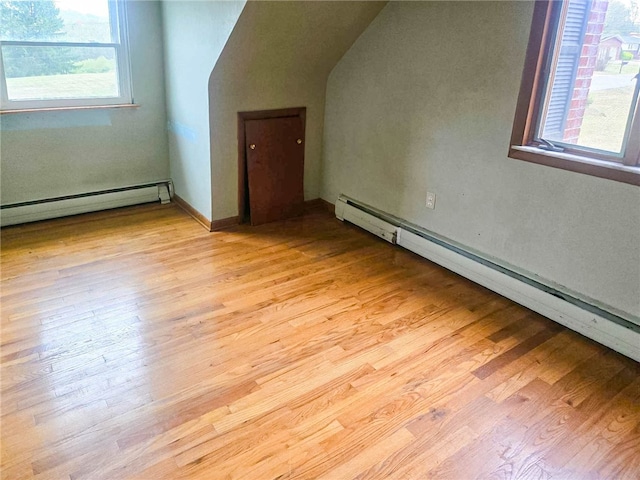 bonus room with a baseboard radiator and light hardwood / wood-style floors