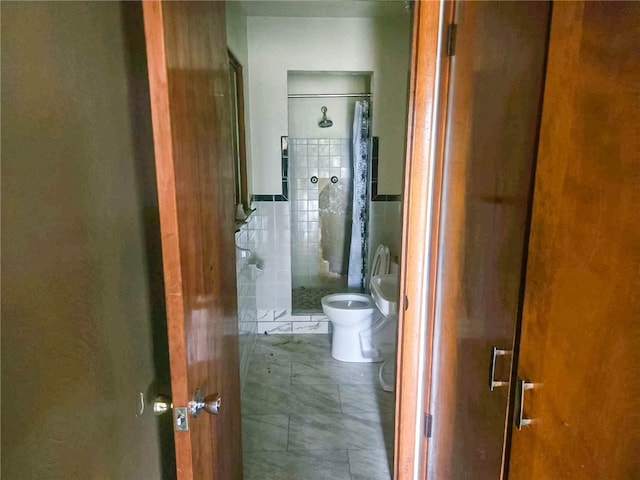 bathroom featuring tile walls, an enclosed shower, and toilet