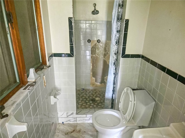 bathroom with tiled shower, toilet, and tile walls