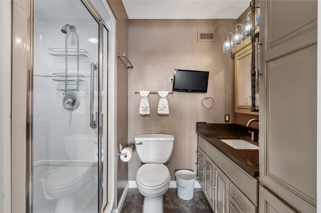 bathroom with vanity, a shower with shower door, and toilet