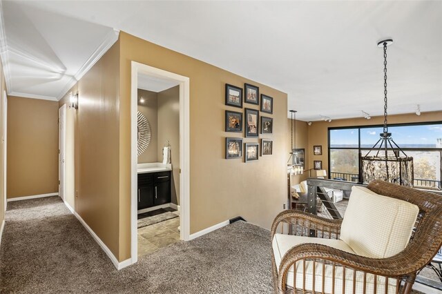 hallway featuring carpet flooring, crown molding, and a notable chandelier