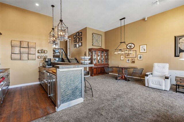 kitchen featuring a kitchen breakfast bar, dark hardwood / wood-style flooring, and hanging light fixtures