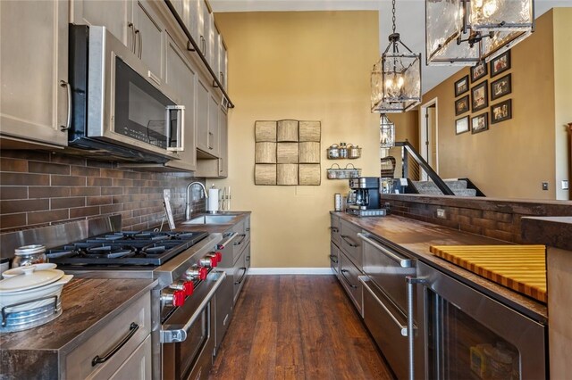 kitchen featuring wine cooler, dark hardwood / wood-style flooring, butcher block countertops, decorative light fixtures, and appliances with stainless steel finishes