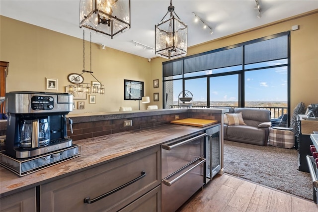 kitchen featuring hardwood / wood-style floors, butcher block countertops, beverage cooler, and pendant lighting