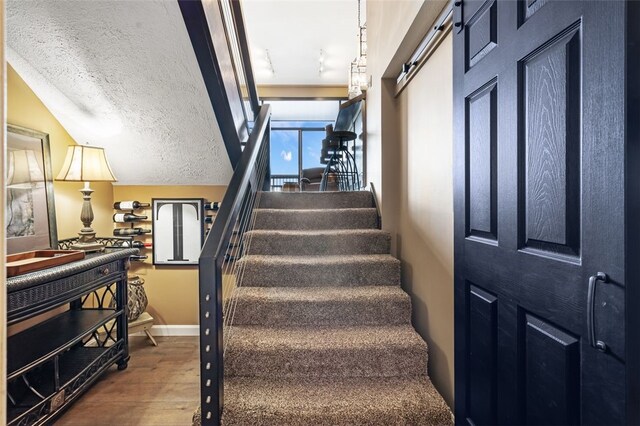 stairway featuring hardwood / wood-style floors and a textured ceiling