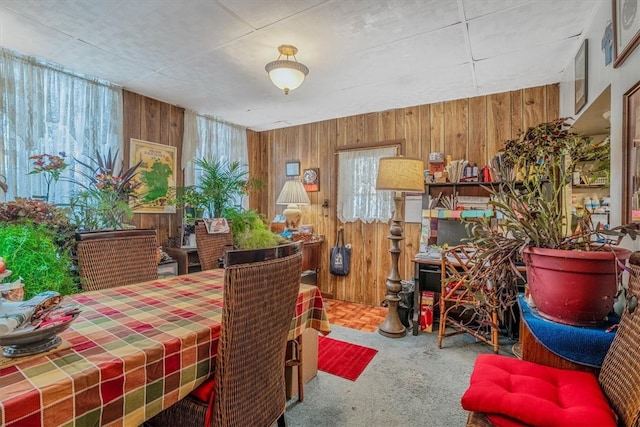 dining room featuring carpet and wooden walls