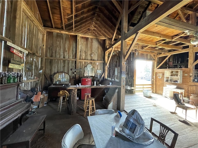 miscellaneous room featuring wooden walls and vaulted ceiling