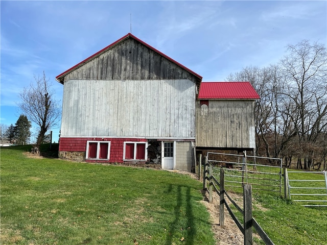 rear view of property with an outbuilding and a yard