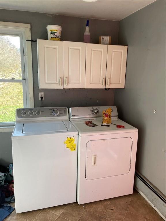 laundry area featuring tile patterned flooring, cabinets, separate washer and dryer, and a baseboard radiator